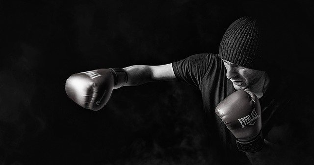 Muž s čiapkou na hlave, v boxerských rukaviciach boxuje do prázdna.jpg